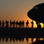 soldiers in line to get in a plane